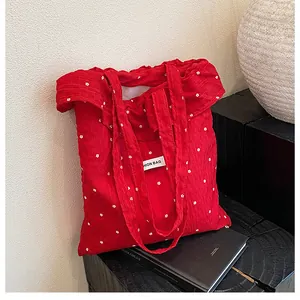 Close-up of a red floral tote bag with a Fashion Bag label on a minimalist display