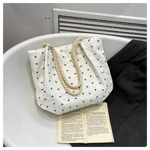 Détail du sac plissé blanc avec imprimé nœuds noirs et anses en corde tressée