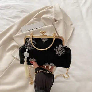 Detail of vintage shell bag with floral embroidery, gold handle and white tassel