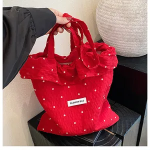 Close-up of red floral fabric tote bag featuring a white Fashion Bag woven label