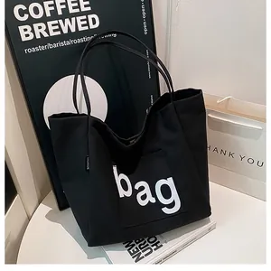 Sac fourre-tout en toile noire avec imprimé bag sur une table de café minimaliste