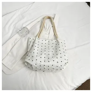 Détail du sac fourre-tout matelassé blanc avec motifs nœuds et poignées en corde