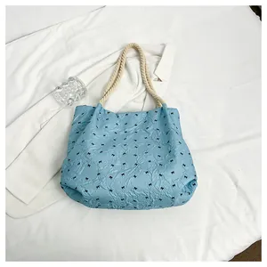 Vue de dessus d'un sac seau bleu à petits nœuds noirs et poignée en corde tressée