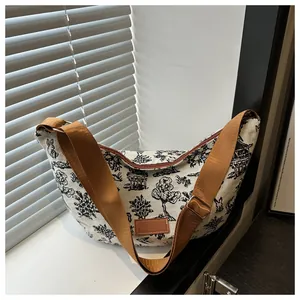 Detail of crescent canvas tote bag showing vintage animal print and leather logo tag