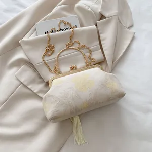 Close-up of floral jacquard shell bag with relief handle and silk fringe detail