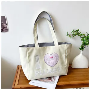 Detailed view of corduroy tote bag lining with internal pocket and plush heart print