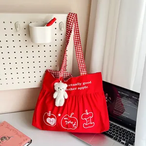 Red large travel tote with apple print, ruffle design, and cute bear plush pendant