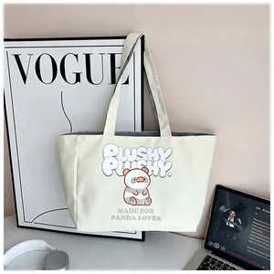 Close-up of cream corduroy tote bag featuring a cartoon panda print and shoulder straps
