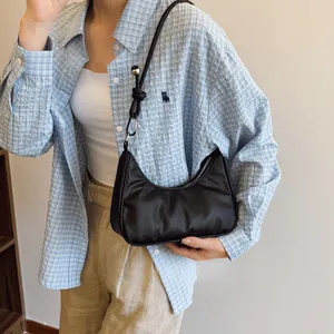 Dettaglio di una borsa hobo nera con fibbie in metallo argento e design a tracolla annodata