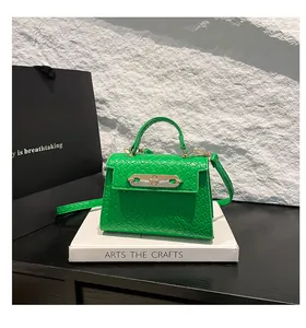 Detail of bright green mini handbag featuring woven texture and golden twist-lock closure