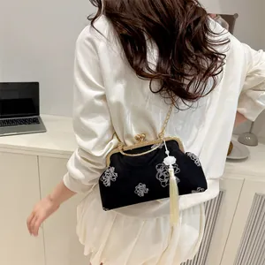 Traditional Chinese style black embroidered handbag with gold clasp and jade tassel