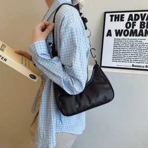 Dettaglio della borsa hobo nera con fibbie in metallo argento e tracolla larga