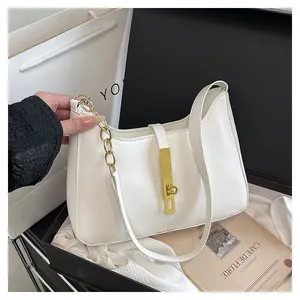 Close-up of white leather hobo bag with gold metal clasp and luxury chain detail