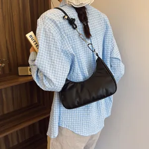 Dettaglio della borsa hobo nera con tracolla annodata e decorazioni in metallo