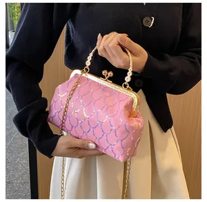 Detail der rosa Pailletten-Abendtasche mit Goldrahmen und kugelförmigem Metallverschluss