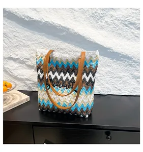 Detailansicht der Strohtasche mit Zickzackmuster und Summer-Schriftzug auf schwarzem Holz