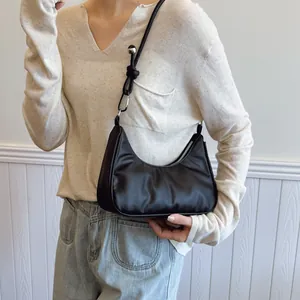 Dettaglio borsa hobo con nodo decorativo e perla metallica argentata sulla tracolla elegante