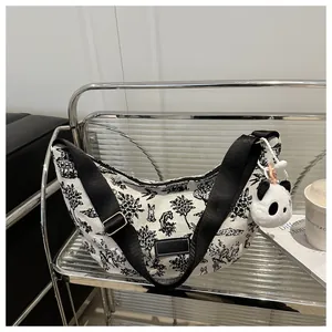 Detail view of canvas tote bag with black and white nature print and panda charm