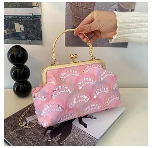 Detail of pink sequin evening bag with gold floral handle and delicate chain strap