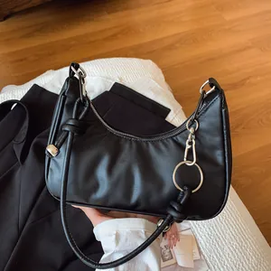Dettaglio di una borsa hobo a mezzaluna nera con finiture argentate su sfondo moderno