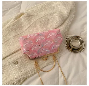 Detail of pink sequin embroidered evening bag with gold metal frame and ring handle