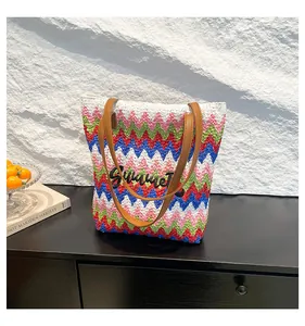 Detail einer bunten Stroh-Tote-Bag mit Summer-Stickerei und braunen Kunstledergriffen