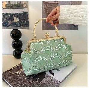 Detail of light green lace sequin evening bag with gold metal ring handle and chain