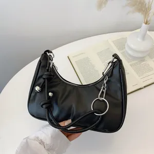 Dettaglio della borsa hobo nera con perline argentate decorative e cinturino con nodo