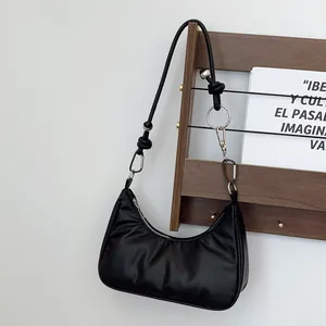 Dettaglio della borsa a mezzaluna nera con cerniere in argento e accenti di tracolla a nodi
