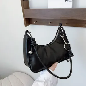 Dettaglio borsa hobo nera con manico annodato, perline argentate e anello in metallo