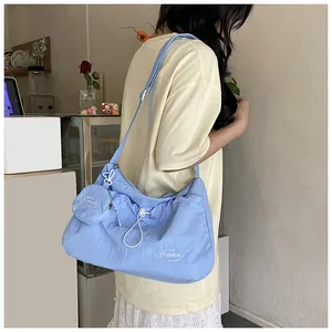 Detail of light blue pleated canvas tote bag with adjustable strap and fashion logo