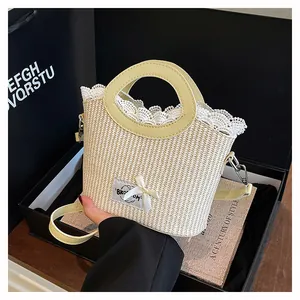 Détail du sac en paille tissé avec bordure en dentelle, poignées cuir et nœud élégant