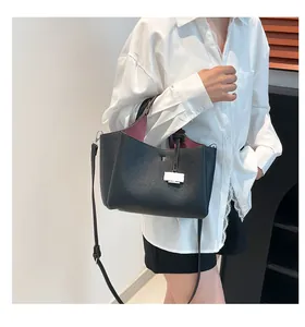 Close-up of black lychee grain leather bucket bag with contrast red interior lining