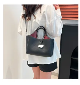 Detail of black pebbled leather bucket bag with silver hardware and contrasting red interior