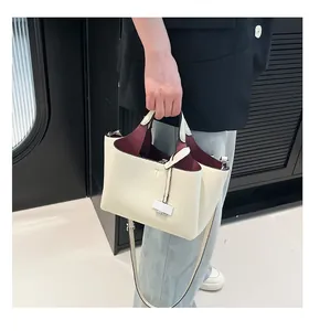 Detail of soft white leather bucket bag with red lining and adjustable shoulder strap
