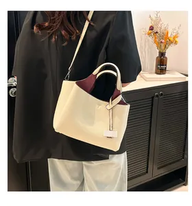 Detail of soft lychee-grain leather bucket bag in cream white with burgundy interior