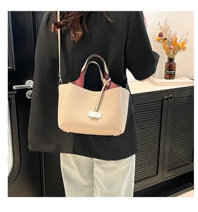 Lifestyle shot of large soft beige bucket bag with contrast lining and long shoulder strap