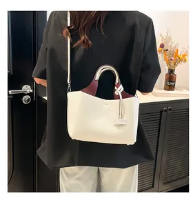 Close-up of white and burgundy lychee grain leather handbag with stylish shoulder strap