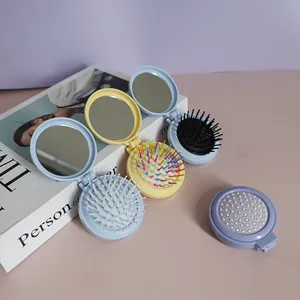 Detailansicht der klappbaren Haarbürste mit Spiegel in Pastell-Macaron-Farben