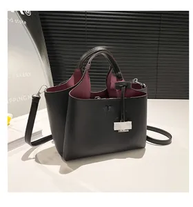 Detail of black lychee grain leather tote bag with contrasting burgundy interior lining