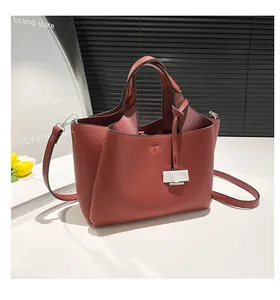 Detail view of terracotta pebbled leather bucket bag with silver buckle and tulip decor
