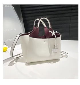 Detail view of the white pebble leather bucket bag with rich burgundy interior lining