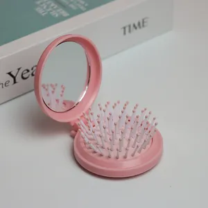 Makroaufnahme der rosa Klappbürste mit integriertem Kosmetikspiegel und weichem Luftkissen