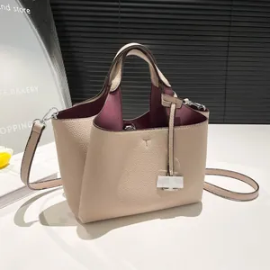 Beige pebble leather bucket bag with burgundy interior and stylish T-embossed detail