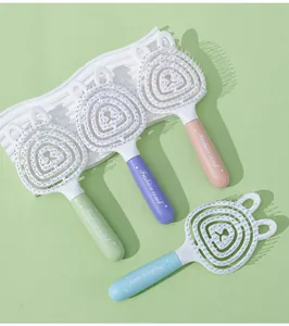 Détail de quatre brosses à cheveux ajourées ours macaron avec poils de massage du cuir chevelu