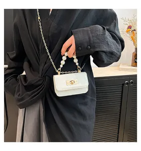 Close-up of white croc-embossed jelly bag with pearl handle and golden twist lock