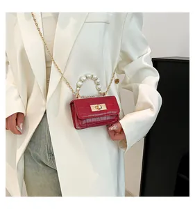 Detailed view of red crocodile-pattern mini bag with pearl handle and golden chain