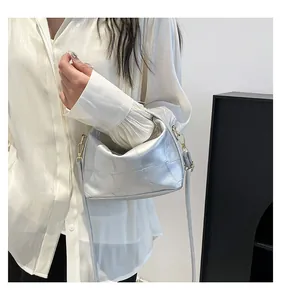 Détail de la texture patchwork argentée du sac seau avec des finitions métalliques dorées