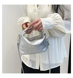Détail du sac seau argenté métallisé montrant le patchwork texturé et la bandoulière