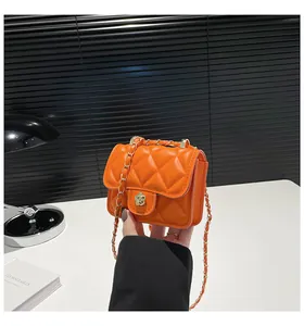 Detailansicht der hellorangen gesteppten Mini-Tasche mit goldenem Blumenschloss